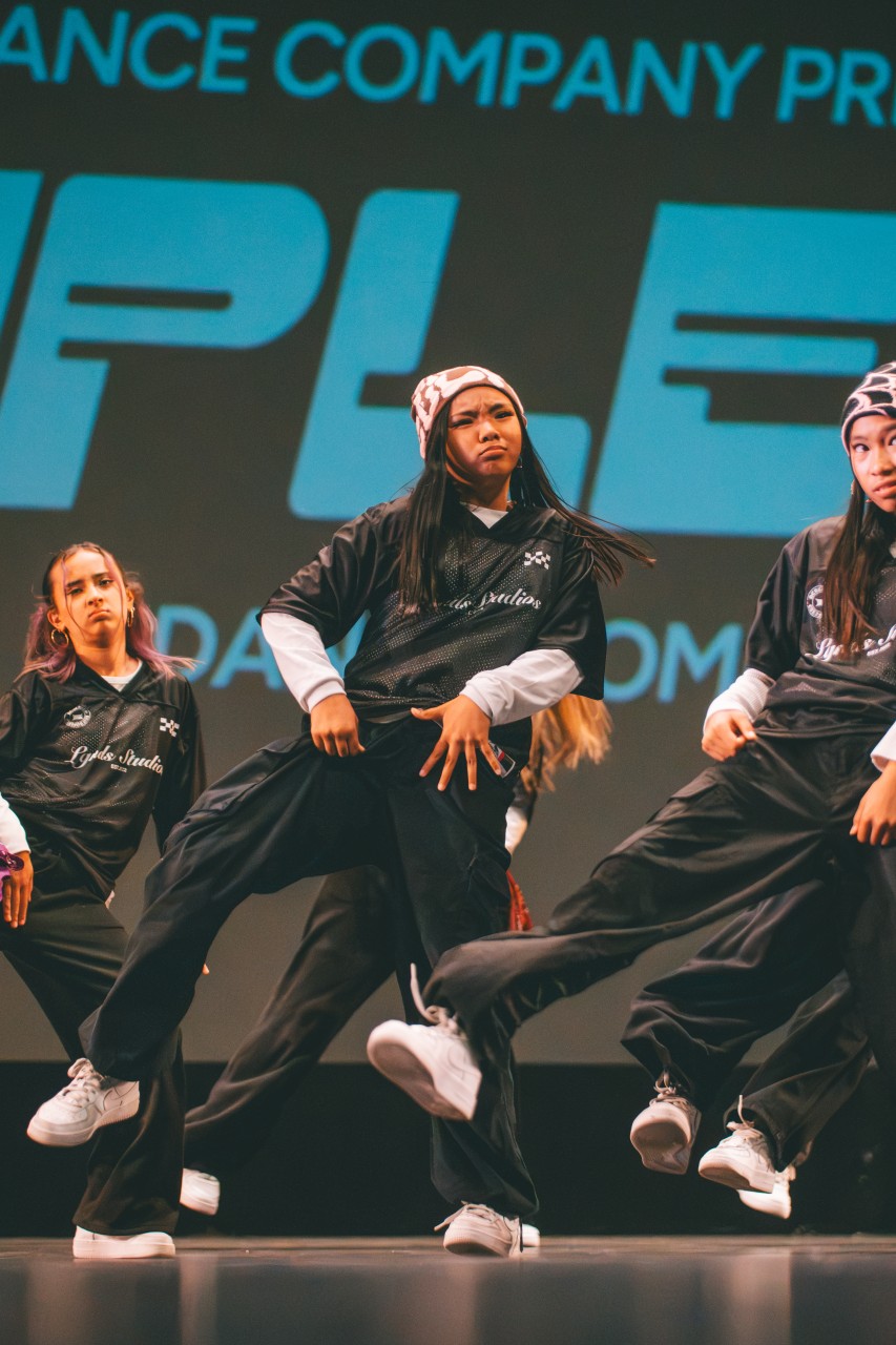 LGNDS dancers performing synchronized hip-hop choreography on a competition stage.